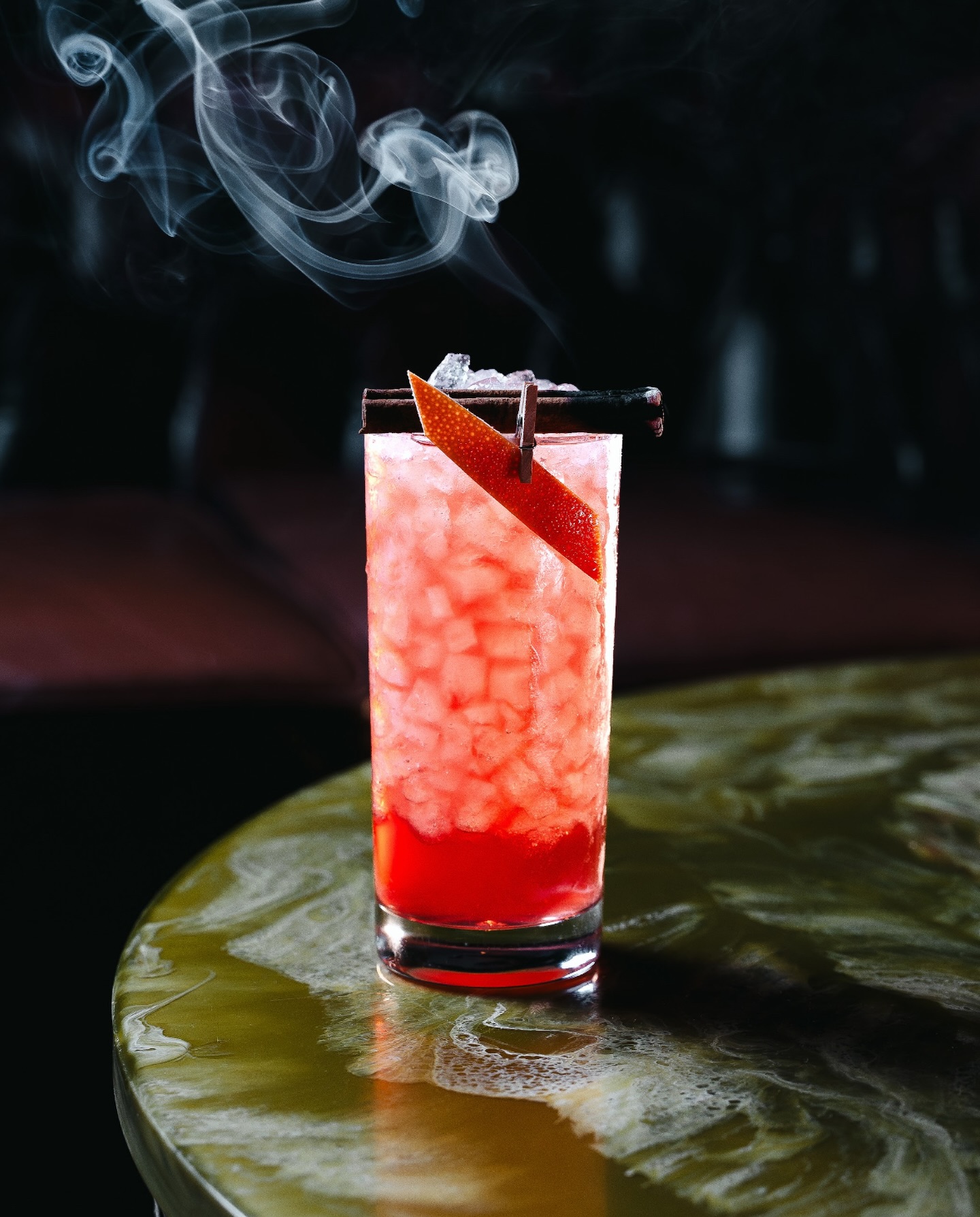 Tiki Wonderland in hoge highball met crushed ice, sinaasappel-twist op kaneelstokje en rook in WonderBar Genk